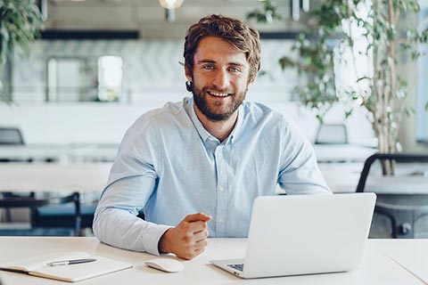 Master franchisee sitting at desk with laptop